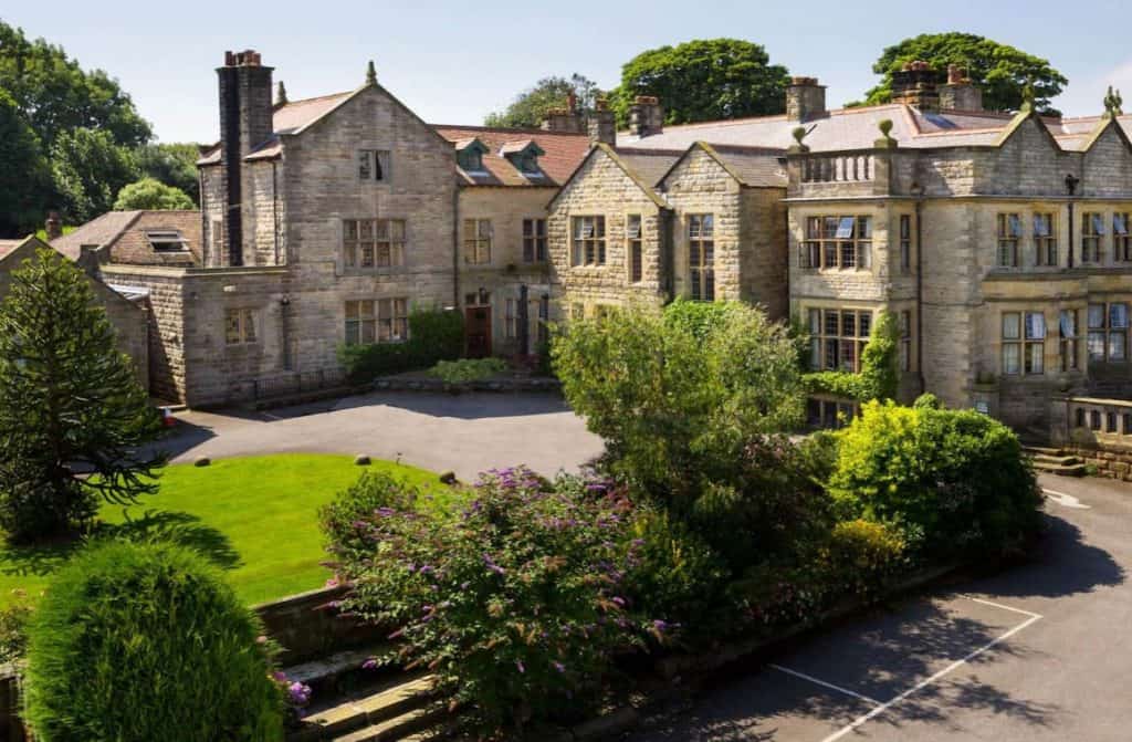 The inviting exterior of Dunsley Hall, with its charming stone walls and lush gardens, providing guests with a serene retreat to explore the U.K.'s rich heritage.