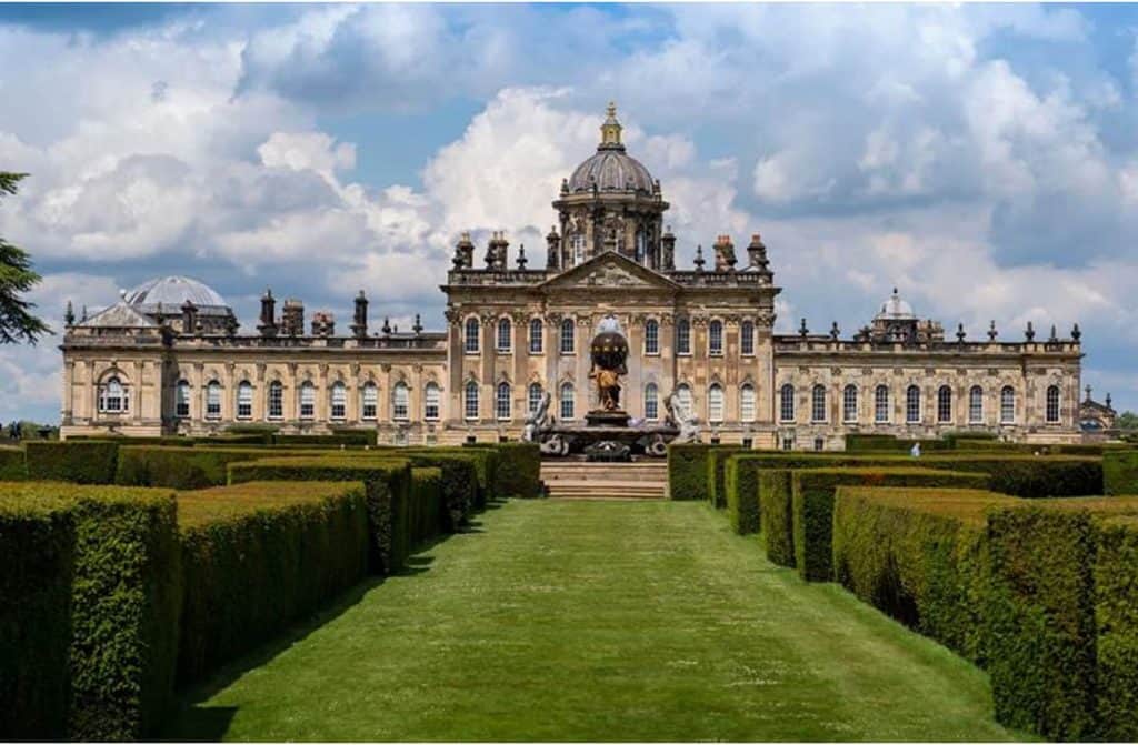 10 Unique Places to Stay in Castles, Manors, and More - The magnificent facade of Castle Howard surrounded by lush gardens, inviting guests to step back in time and experience the grandeur of the U.K.'s storied past.
