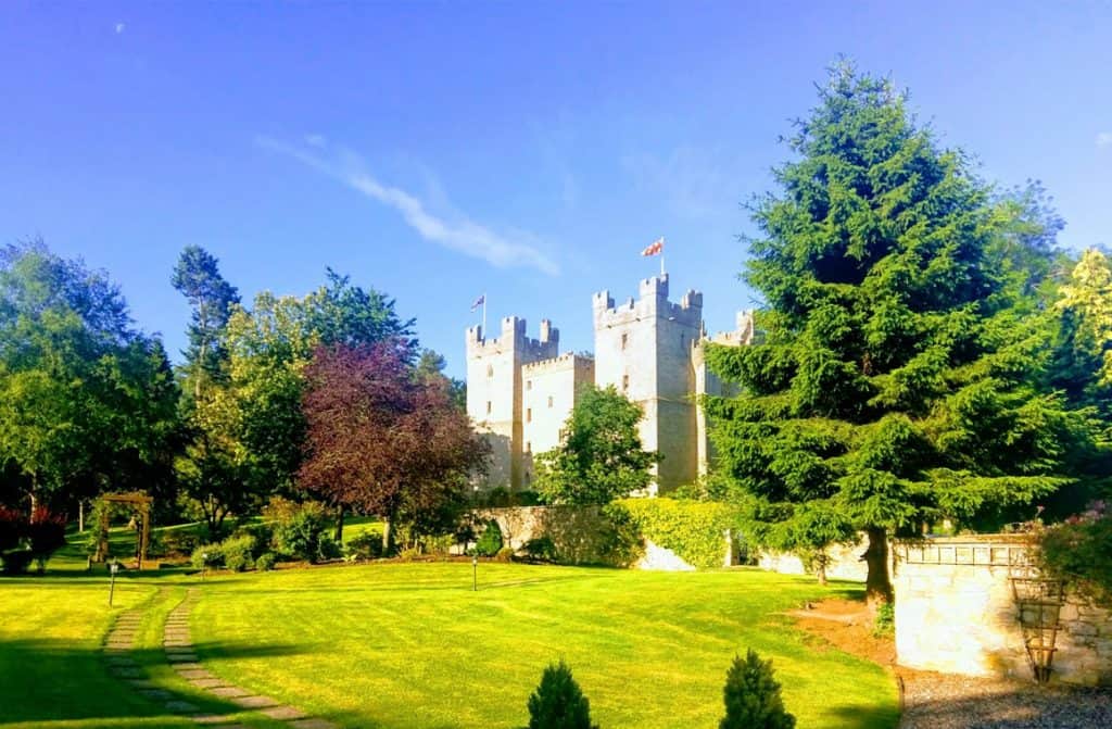 The stately Langley Castle, with its impressive stone facade and verdant surroundings, offering guests a lavish retreat infused with the rich heritage of the U.K.