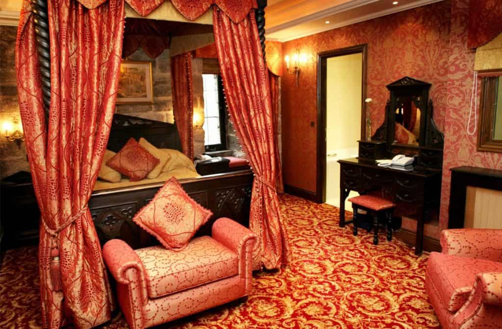 A luxurious room within Langley Castle, featuring regal furnishings, rich textiles, and stately décor, transporting guests to a world of historic refinement and comfort.