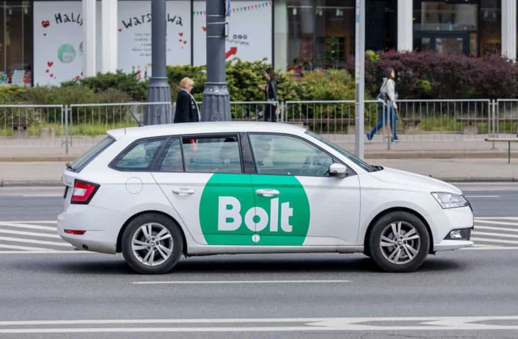 A Bolt car on the road, presenting a budget-friendly and convenient airport transfer option in the UK.