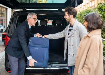 An airport transfer shuttle bus ready to pick up passengers, offering a budget-conscious option for UK travelers.
