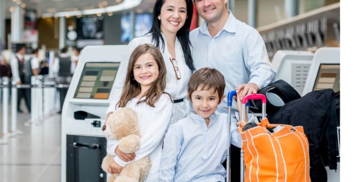 A family with luggage standing near a van, ready for airport transfer.