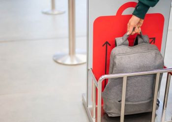 Airline staff checking the size and weight of luggage at the airport.