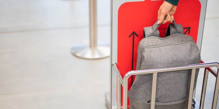 Airline staff checking the size and weight of luggage at the airport.