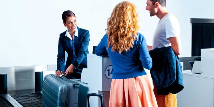 A traveler's luggage on a weighing scale at an airport check-in counter, illustrating the process of adhering to the checked baggage weight restrictions set by airlines in 2023.