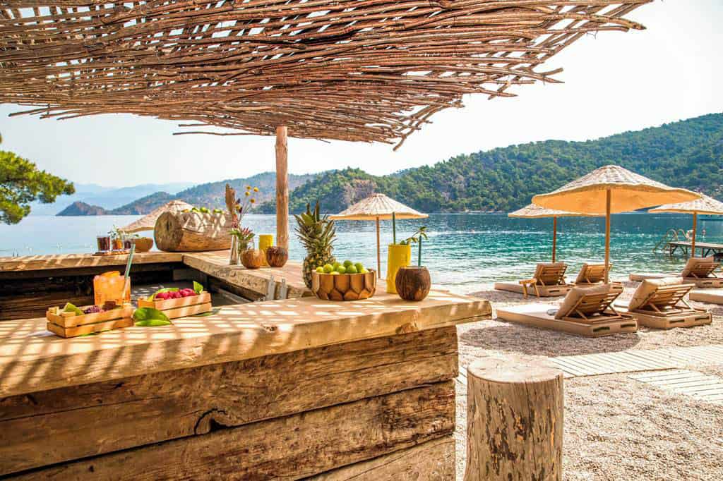 Breathtaking beauty of Hillside Beach in Fethiye, Turkey. The focus is on a serene, picturesque beachfront, with gentle waves washing over the golden sands.