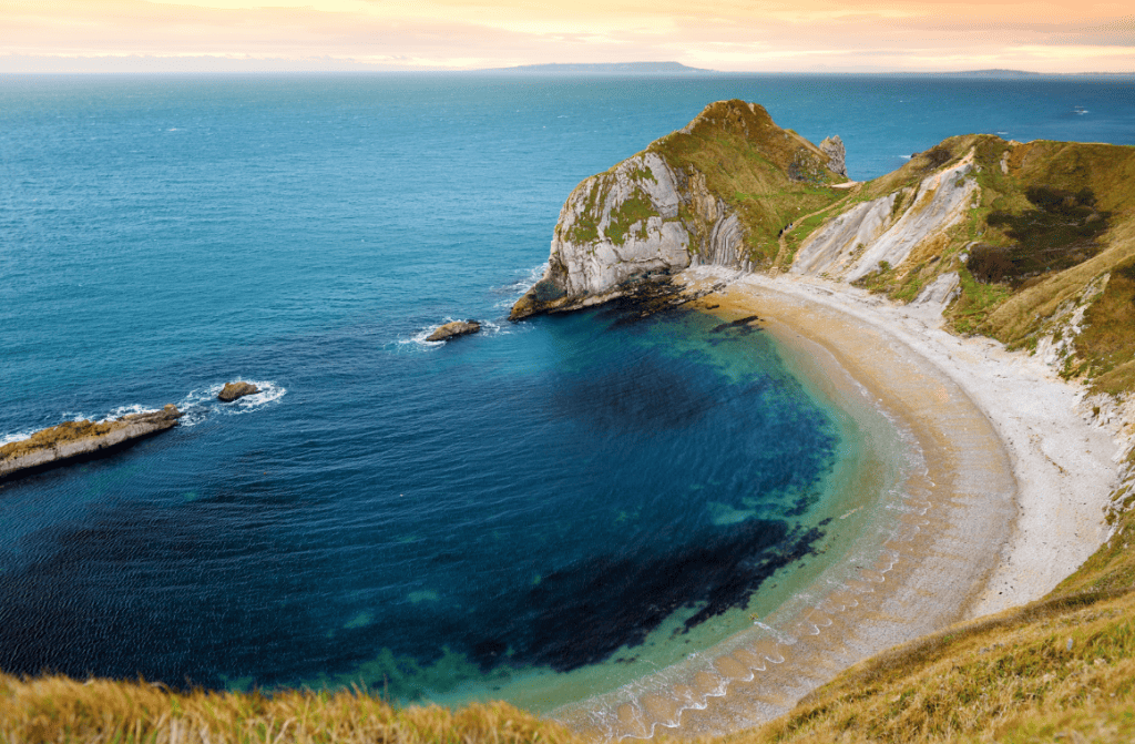Scenic view of Man O'War Cave at Jurassic Coast, England, with rugged cliffs and ocean.
