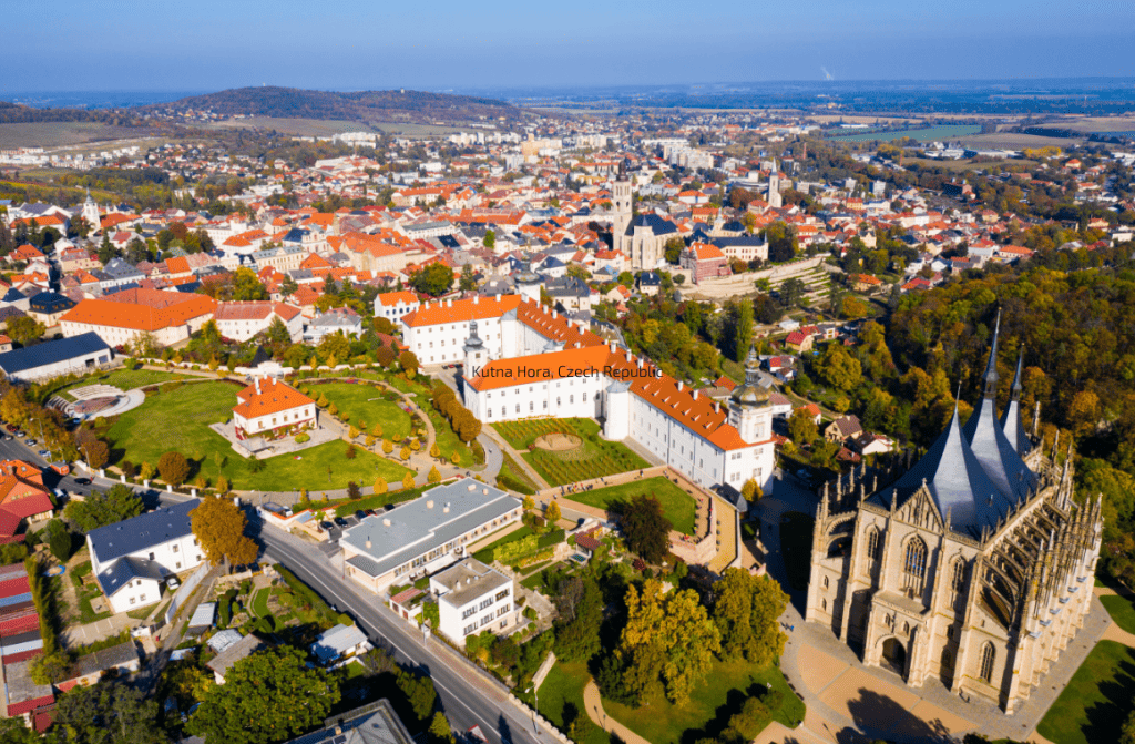 Gothic splendor of Kutna Hora, Czech Republic, featuring St. Barbara's Church, historical buildings, and cobblestone streets amidst lush greenery.